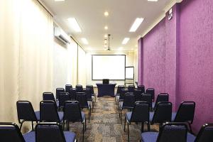 einen Konferenzraum mit lila Wänden und Stühlen in der Unterkunft Transamerica Executive Perdizes in São Paulo