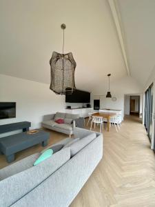 a living room with a couch and a table at Magnifique villa avec piscine, à 5 min des plages in Landunvez