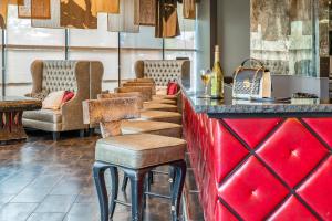 a bar with a row of stools in a restaurant at Hotel Huntington Beach in Huntington Beach