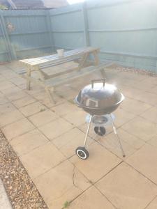 a grill and a picnic table on a patio at Rabbit Haven - 4 minutes from Bicester Village! in Bicester