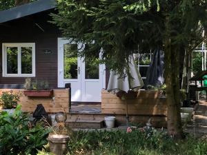 ein Haus mit einer Veranda mit einer weißen Tür in der Unterkunft Vakantie Boshuisje Meibloempje in Lanaken