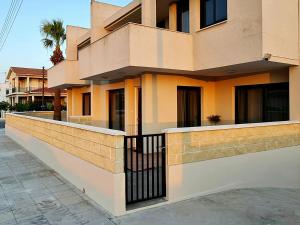 a building with a fence on the side of it at PylaApts - Apartments near the beach in Pyla
