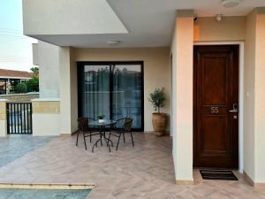 a patio with a table and chairs and a door at PylaApts - Apartments near the beach in Pyla