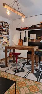 a room with a wooden table and guitars on the wall at Ostello Exclusive Dependance - IT CLOSES AT NINE PM in Palermo