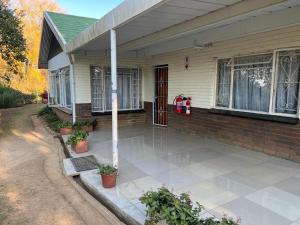 a house with a front porch with a patio at The Big Five Bed and breakfast in Mooirivier