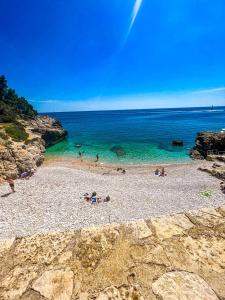 a group of people on a beach near the water at Arena city apartment in Pula