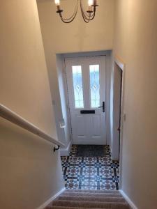 a hallway with a door with a window and stairs at Character cottage in centre of Moffat in Moffat