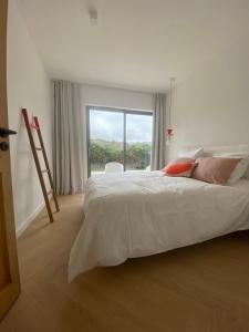 a bedroom with a large bed with a large window at Magnifique villa avec piscine, à 5 min des plages in Landunvez