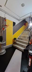 a staircase in an office with a yellow and gray wall at Exclusive Dependance in Palermo