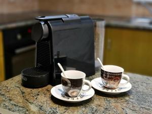 two coffee cups sitting on top of a counter at PylaApts - Apartments near the beach in Pyla