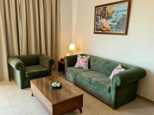 un soggiorno con divano verde e tavolino da caffè di PylaApts - Apartments near the beach a Pyla