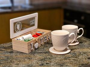 a table with two coffee cups and a microwave at PylaApts - Apartments near the beach in Pyla
