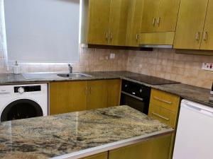 a kitchen with a sink and a washing machine at PylaApts - Apartments near the beach in Pyla