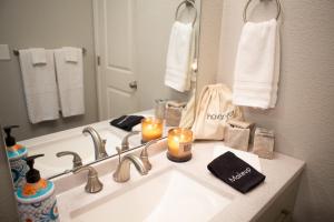 a bathroom with a sink with candles and a mirror at The Blue Door Bungalow - Oldtown, Well-Equipped Kitchen in Loveland +16 photos