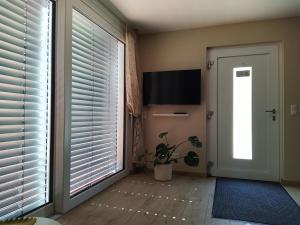 - un couloir avec une porte, une télévision et une fenêtre dans l'établissement Ferienhof Dachsberg Wohnung Sundowner, à Bermatingen