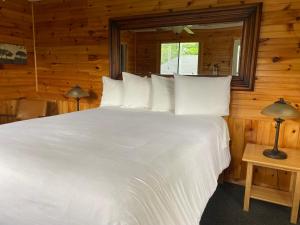 a bedroom with a large white bed in a cabin at Hotel Kenney Rideau in Crosby