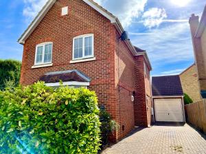 a red brick house with a white garage at Luxury 3 Bed Detached Home In Windsor in Dorney