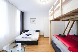 1 dormitorio con 2 literas y mesa de cristal en CozyNite Premium Apartment Schönbrunn 1, en Viena