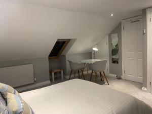 a bedroom with a bed and a table with chairs at Rosenn Teyr in St. Agnes 