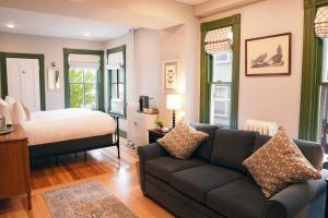 a living room with a couch and a bed at Chart House Inn in Newport