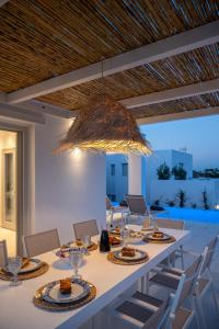 a dining room with a long table with chairs at Sunsenses villa Ariadne in Piso Livadi