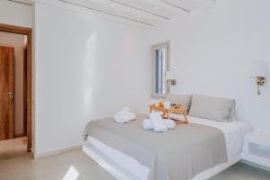 a white room with a bed with towels on it at Sunsenses villa Ariadne in Piso Livadi