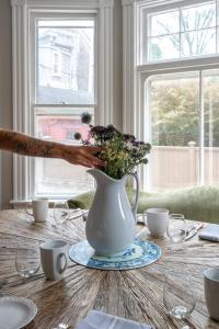 a vase with flowers in it sitting on a table at Chart House Inn in Newport +26 photos
