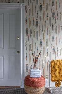 a room with a chair and a wall with feathers at Chart House Inn in Newport