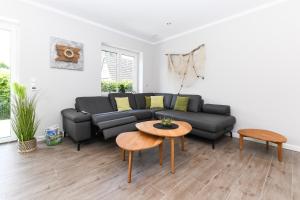 a living room with a black couch and a table at Ferienhaus Nordseeperle Neuharlingersiel in Neuharlingersiel