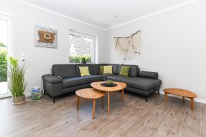 ein Wohnzimmer mit einem Sofa und einem Tisch in der Unterkunft Ferienhaus Nordseeperle Neuharlingersiel in Neuharlingersiel