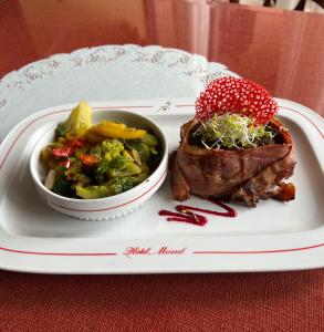 um prato de comida com um bife e uma tigela de vegetais em Hotel Mosul em Concepción