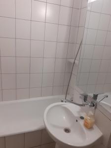 Baño blanco con lavabo y bañera en Good luck apartament, en Mediaş 17 fotos más