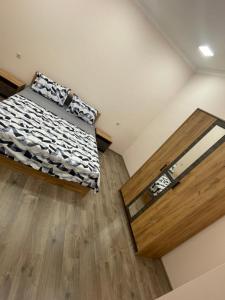a bedroom with a bed and a wooden floor at Albus house in Gyumri