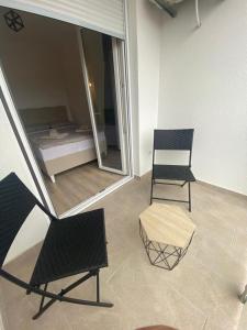 2 Stühle und ein Tisch in einem Zimmer mit einem Bett in der Unterkunft SMILJANA in Banja Koviljača