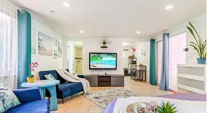 a living room with a blue couch and a tv at Close to beaches with hot tub and large garden in Sarasota