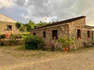 a stone building with a bench in front of it at Casa rural La Portilla in Aroche