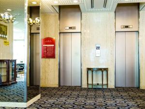 um átrio com quatro elevadores e um banco num edifício em City Hotel Air Port in Prince - Vacation STAY 80750v em Izumi-Sano