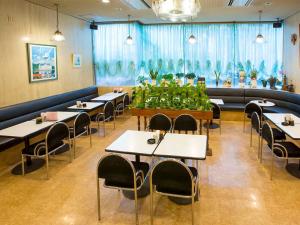 uma sala de jantar com mesas, cadeiras e plantas em City Hotel Air Port in Prince - Vacation STAY 80750v em Izumi-Sano