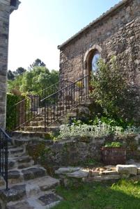 an old stone building with stairs and a fence at Gite rural au calme en Cévennes Gardoises in Saint-Jean-du-Gard