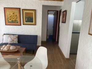 a living room with a blue couch and a table at Dpto pequeño y acogedor en zona ideal de la Bahía in Paracas +11 photos