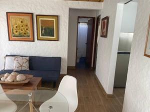 sala de estar con sofá azul y mesa en Departamento pequeño 2 BR en zona ideal de Paracas, en Paracas