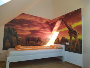 1 dormitorio con un mural de jirafas y elefantes en Ferienhof-Dachsberg Wohnung Highlander, en Bermatingen