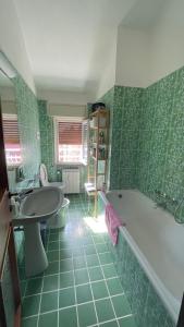baño verde con bañera y lavamanos en Sea front attic, en Chiavari