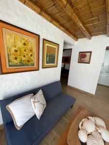 sala de estar con sofá azul y algunas fotografías en Departamento pequeño 2 BR en zona ideal de Paracas, en Paracas