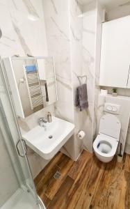 a white bathroom with a sink and a toilet at Apartman Filipović in Banja Luka