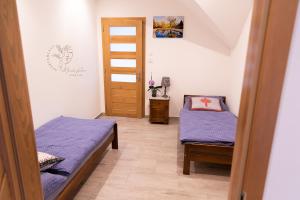 a small room with two beds and a door at Apartamenty Home&Spa in Rabka-Zdrój