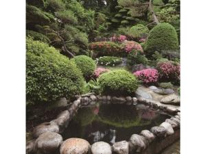 un jardín con un estanque con arbustos y flores en Tohoku Onsen - Vacation STAY 08516v en Towada
