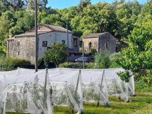un jardín con redes blancas frente a una casa en Gite rural au calme en Cévennes Gardoises, en Saint-Jean-du-Gard