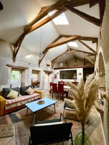 a living room with a couch and a table at Ô Trois Puits in Laburgade