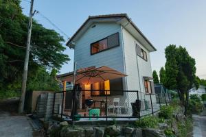 ein kleines Haus mit einem Regenschirm davor in der Unterkunft Awaji Aqua Marine Resort Building No, 3 - Vacation STAY 09371v in Awaji